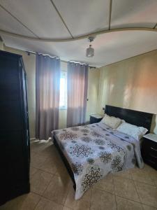 a bedroom with a bed with a blanket on it at Appartement famille plage in El Jadida