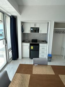 eine Küche mit weißen Schränken und einem schwarzen Herd in der Unterkunft Hermosa Suite a Pie de Playa en Acapulco in Acapulco