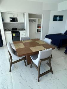 einen Holztisch und Stühle im Wohnzimmer in der Unterkunft Hermosa Suite a Pie de Playa en Acapulco in Acapulco + 5 Fotos