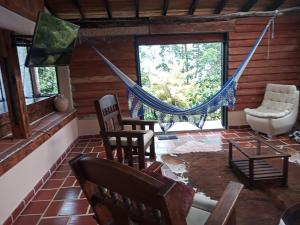 a living room with a hammock in a log cabin at Paz y Tranquilidad in Marsella