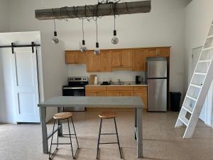 a kitchen with a table and two stools at Mezzanine Loft Above the Barn in Whitehorse
