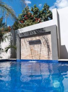 una piscina con una pared de ladrillo y una fuente de agua en Surf VIP location, en Cóbano 7 fotos más