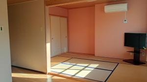 een lege kamer met een deur en een televisie bij 坂聖 那須塩原 in Nasushiobara