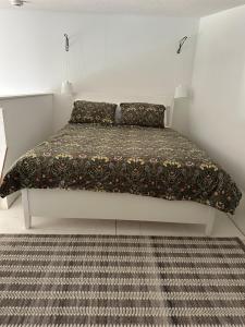 a bedroom with a bed with a blanket and a rug at Mezzanine Loft Above the Barn in Whitehorse