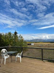 a patio with a table and two chairs on a deck at Mezzanine Loft Above the Barn in Whitehorse
