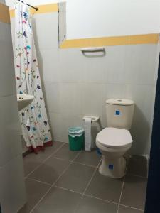 a bathroom with a toilet and a shower curtain at Hotel casa reina in Ibagué