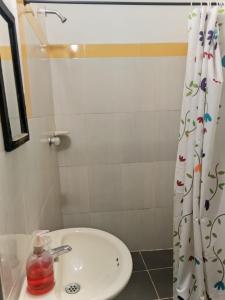 a bathroom with a sink and a shower curtain at Hotel casa reina in Ibagué