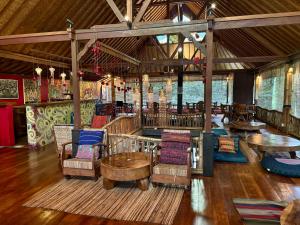 a restaurant with tables and chairs in a room at Bali Bohemia Huts in Ubud