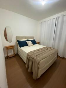 a bedroom with a large bed with blue pillows at Conforto e aconchego em São João del-Rei in São João del Rei +23 photos