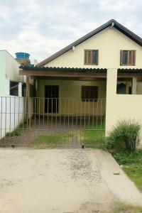 uma casa com uma cerca na frente em Casa da família Castro em Capão da Canoa