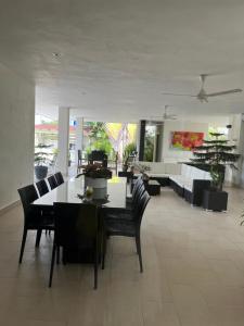 a dining room with a table and chairs and a couch at Villa las orquídeas terraza y piscina grande, vista a la montaña!! in San Felipe de Puerto Plata