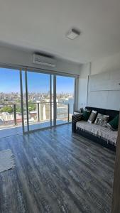 a large living room with a bed and large windows at Stylish Modern apartment with automatic parking in Buenos Aires