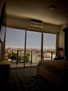 a bedroom with a large window with a view of a city at Stylish Modern apartment with automatic parking in Buenos Aires +33 photos