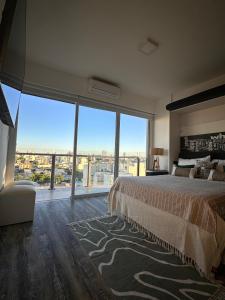 a bedroom with a large bed and a large window at Stylish Modern apartment with automatic parking in Buenos Aires