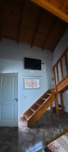 a room with a staircase and a tv on the wall at La curva del molino in Villa Parque Siquiman