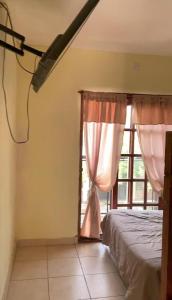 サンルイスにあるEl descanso de los colibrisのベッドと窓のある寝室