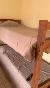 サンルイスにあるEl descanso de los colibrisのリモコンが2つ付いた木製の二段ベッド