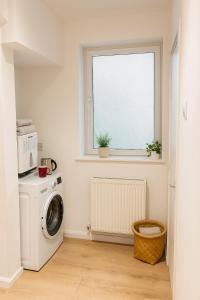 Un lavadero con lavadora y ventana. en Platt Bridge Contractor Stays-One Bedroom house, en Abram