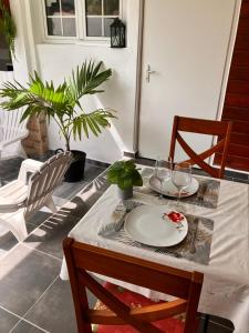 a table with a plate and wine glasses on it at Tilys lodge in Capesterre-Belle-Eau