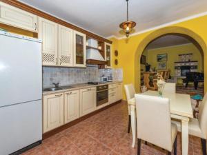 a kitchen with a table and a white refrigerator at Holiday Home Marin AS with Pool in Trbounje