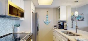 a kitchen with a sink and a refrigerator at Beachfront Space Coast Gem with Heated Pool, Sleeps 4 in Cape Canaveral +13 photos