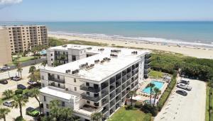 an aerial view of a building and the beach at Beachfront Space Coast Gem with Heated Pool, Sleeps 4 in Cape Canaveral
