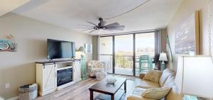 a living room with a couch and a tv at Beachfront Space Coast Gem with Heated Pool, Sleeps 4 in Cape Canaveral