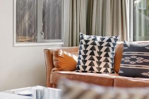 eine Couch mit Kissen darauf in einem Wohnzimmer in der Unterkunft Amazing Location! Central 2 bedroom Unit in Wanaka + 16 Fotos