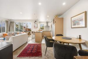 eine Küche und ein Wohnzimmer mit Tisch und Stühlen in der Unterkunft Amazing Location! Central 2 bedroom Unit in Wanaka