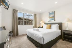 ein Schlafzimmer mit großem Bett und Fenster in der Unterkunft Amazing Location! Central 2 bedroom Unit in Wanaka