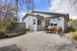 ein Haus mit einem Tisch und Stühlen auf einer Terrasse in der Unterkunft Amazing Location! Central 2 bedroom Unit in Wanaka