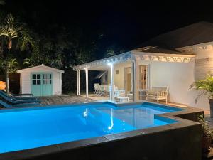 a swimming pool in front of a house at night at Maison Latecoere avec piscine in Le François