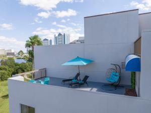 a balcony with a blue umbrella and chairs at New Studio with Private Terrace and Volcano Bay view 5 min EPIC parking free in Orlando