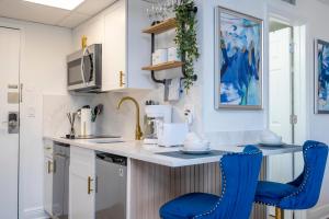 a kitchen with two blue chairs at a counter at New Studio with Private Terrace and Volcano Bay view 5 min EPIC parking free in Orlando
