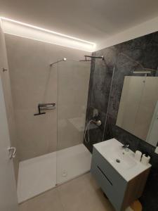 a bathroom with a glass shower and a sink at Casa Gisella Surf House in Ladispoli