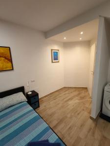 a bedroom with a bed and a wooden floor at Casa Gisella Surf House in Ladispoli