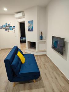 a living room with a blue couch and a tv at Casa Gisella Surf House in Ladispoli
