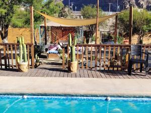 a pool with a gazebo and cactuses next to a fence at Casa Refugio con Tinaja privada en Rivadavia in Vicuña