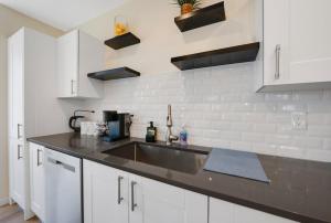 a kitchen with white cabinets and a stainless steel sink at Spacious 5BR Home KING Bed Wi-Fi Parking in Bloomfield