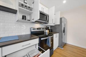 a white kitchen with a stove and a refrigerator at Spacious 5BR Home KING Bed Wi-Fi Parking in Bloomfield +37 photos