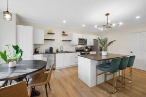 a kitchen with white cabinets and a table and chairs at Spacious 5BR Home KING Bed Wi-Fi Parking in Bloomfield