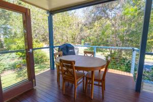 eine Holzterrasse mit einem Tisch und Stühlen auf einer Terrasse in der Unterkunft Melaleuca Lookout - Pet Friendly in Point Lookout