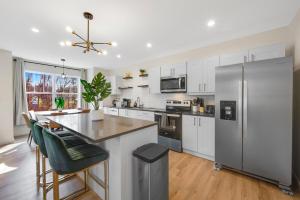 a kitchen with white cabinets and a stainless steel refrigerator at Spacious 5BR Home KING Bed Wi-Fi Parking in Bloomfield