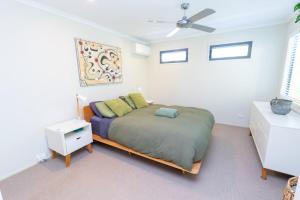 ein Schlafzimmer mit einem Bett und einem Deckenventilator in der Unterkunft Melaleuca Lookout - Pet Friendly in Point Lookout