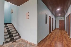 an empty hallway with stairs and doors in a house at Hotel O Drip Inn in Bheta +19 photos