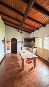 a kitchen with a table and chairs in a room at Il Rustico in Pozzillo