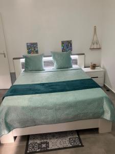 a bedroom with a large bed with a green comforter at Tilys house in Capesterre-Belle-Eau +13 photos
