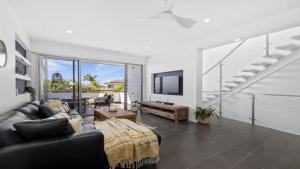 ein Wohnzimmer mit Sofa und Fernseher in der Unterkunft Pacific Piers in Coffs Harbour