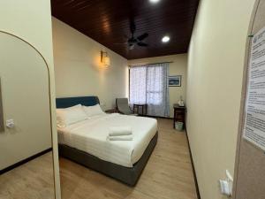 a bedroom with a bed and a window and a mirror at Tranquera House in Ranau