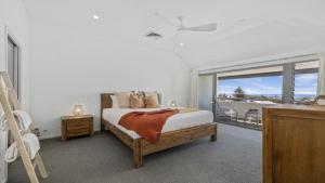 ein Schlafzimmer mit einem Bett und einem Balkon in der Unterkunft Pacific Piers in Coffs Harbour